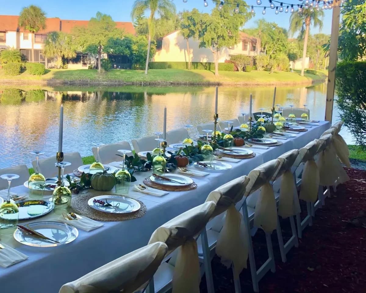 Long tables styled with white covers for an outdoor event